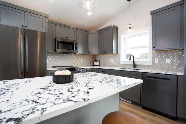 kitchen with appliances with stainless steel finishes, gray cabinetry, and a sink