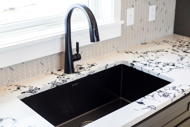 details with light stone countertops, tasteful backsplash, and a sink