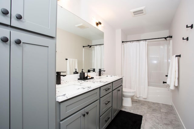 bathroom with double vanity, toilet, visible vents, and a sink