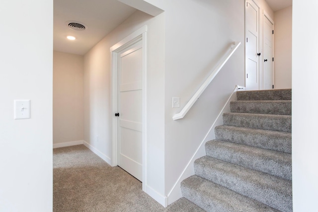 stairway with visible vents, carpet floors, and baseboards