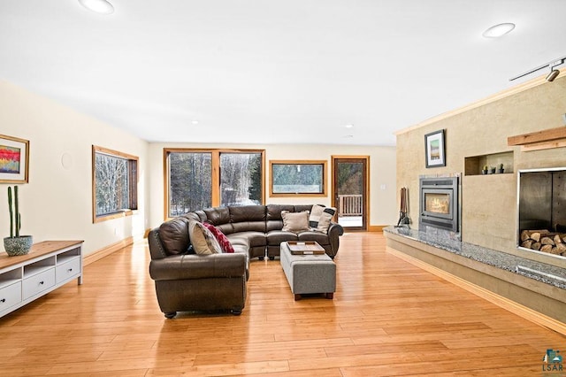 living room with recessed lighting, light wood-type flooring, baseboards, and a premium fireplace