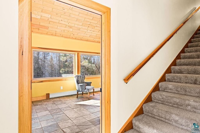 stairway featuring vaulted ceiling, stone finish floor, baseboards, and a baseboard radiator