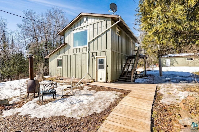 exterior space with stairs, an outdoor structure, board and batten siding, and a wooden deck