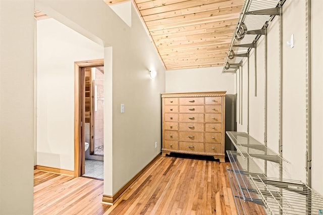 corridor with light wood finished floors, wood ceiling, lofted ceiling, and baseboards