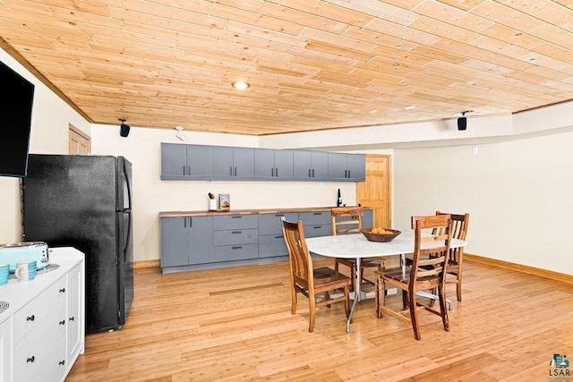 kitchen with gray cabinetry, wooden ceiling, baseboards, freestanding refrigerator, and light wood finished floors
