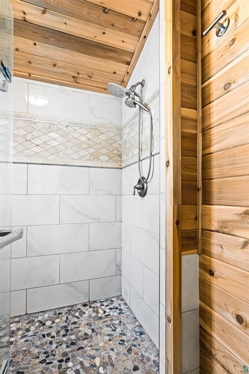 bathroom with tiled shower and wooden ceiling