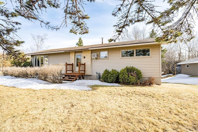 ranch-style home with an AC wall unit and a front yard