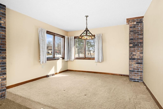 unfurnished room with visible vents, a textured ceiling, baseboards, and carpet