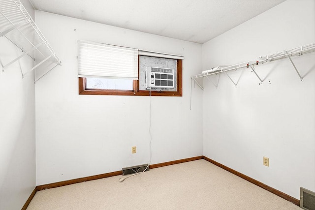 walk in closet with visible vents, carpet floors, and cooling unit