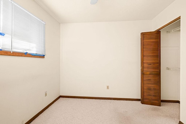 unfurnished bedroom featuring baseboards and light colored carpet