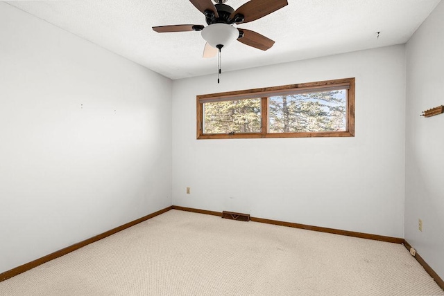 unfurnished room featuring visible vents, baseboards, light colored carpet, and ceiling fan