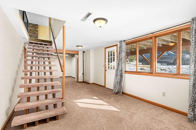 staircase with visible vents, baseboards, and carpet