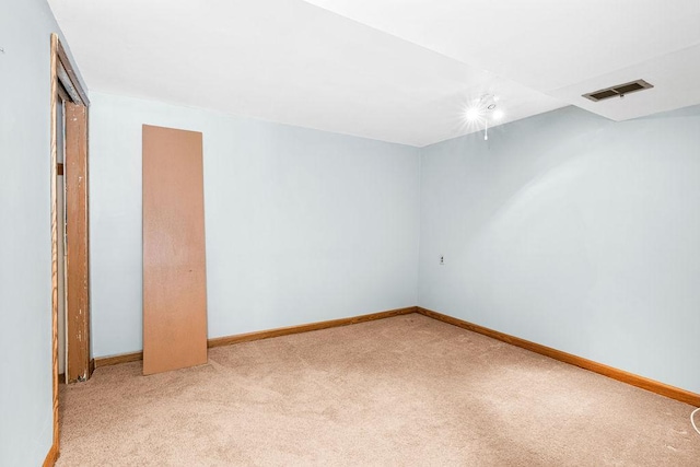 carpeted spare room featuring baseboards and visible vents