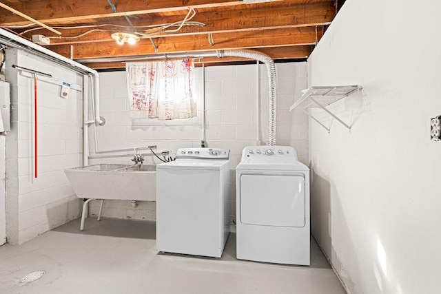 washroom with a sink, electric panel, washing machine and dryer, and laundry area