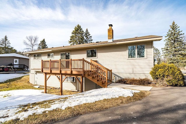 view of front of property with stairs, a wooden deck, and a chimney