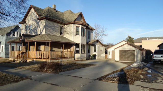 victorian house featuring driveway, a porch, a shingled roof, an outdoor structure, and a garage