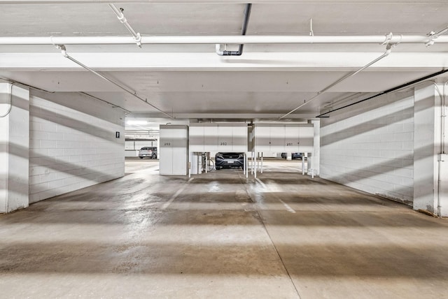 parking deck featuring a garage door opener and concrete block wall