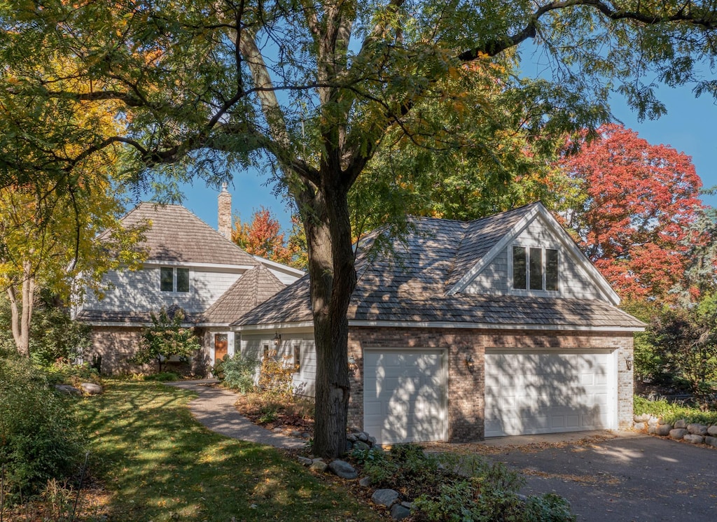 view of side of home with a yard, a garage, and a chimney