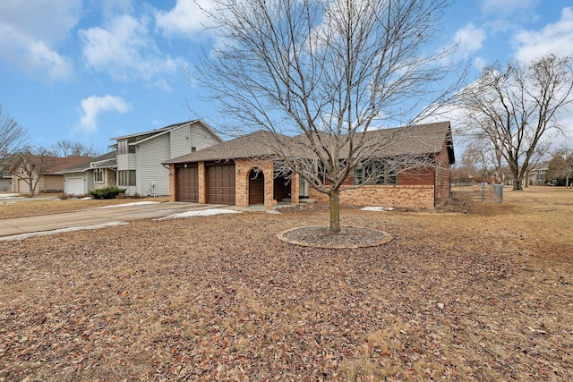 view of front of property featuring an attached garage, brick siding, and driveway