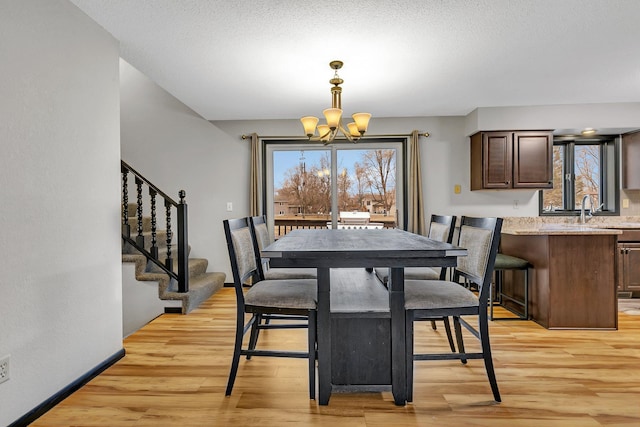 dining space featuring baseboards, an inviting chandelier, stairs, a textured ceiling, and light wood-type flooring