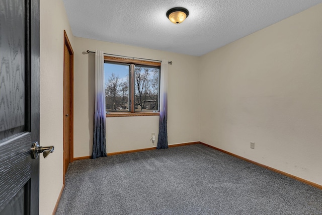 carpeted empty room with baseboards and a textured ceiling