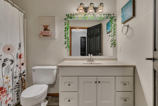 full bath with vanity, toilet, and baseboards