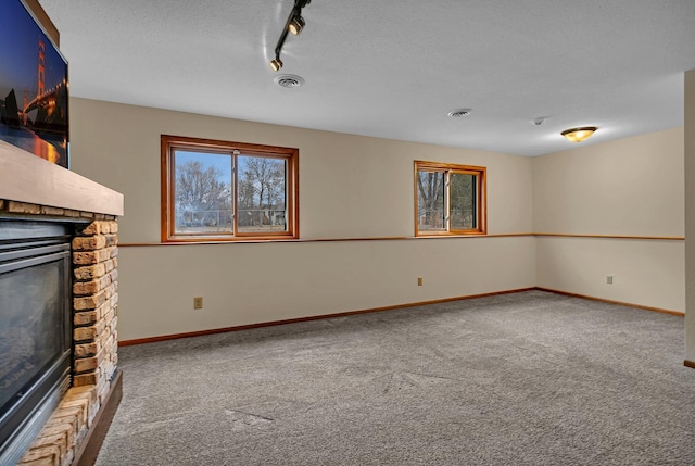 unfurnished living room with baseboards, visible vents, carpet floors, and a brick fireplace