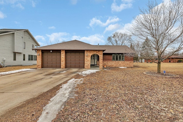 ranch-style house with concrete driveway, an attached garage, brick siding, and a shingled roof