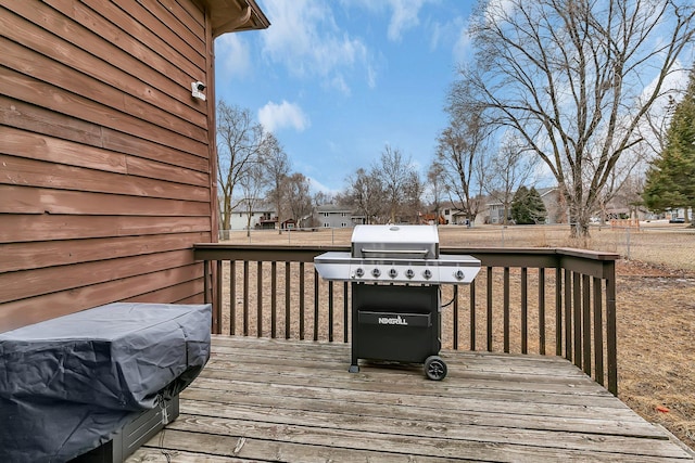 wooden deck featuring a grill and fence