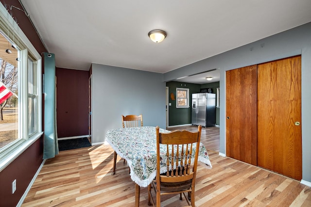 dining room featuring light wood finished floors and baseboards