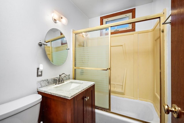 bathroom featuring enclosed tub / shower combo, toilet, and vanity