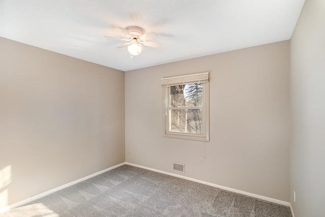 spare room featuring light carpet, visible vents, ceiling fan, and baseboards