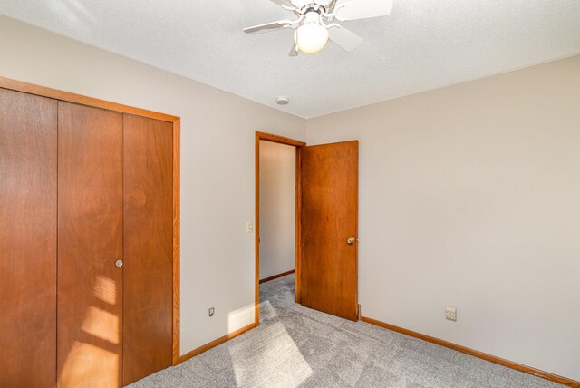 unfurnished bedroom featuring a closet, baseboards, carpet floors, and a textured ceiling