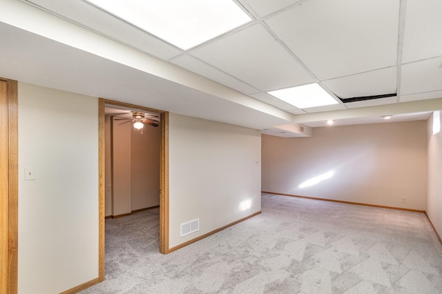 carpeted empty room with visible vents, baseboards, and a drop ceiling