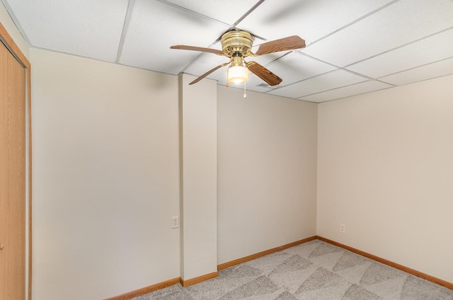 spare room with light colored carpet, baseboards, and a drop ceiling