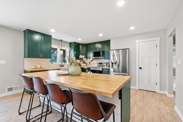 kitchen with wooden counters, visible vents, appliances with stainless steel finishes, and green cabinets