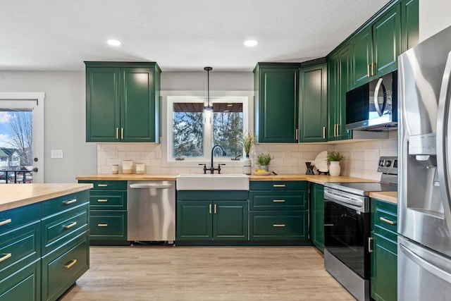 kitchen featuring a sink, green cabinetry, and stainless steel appliances