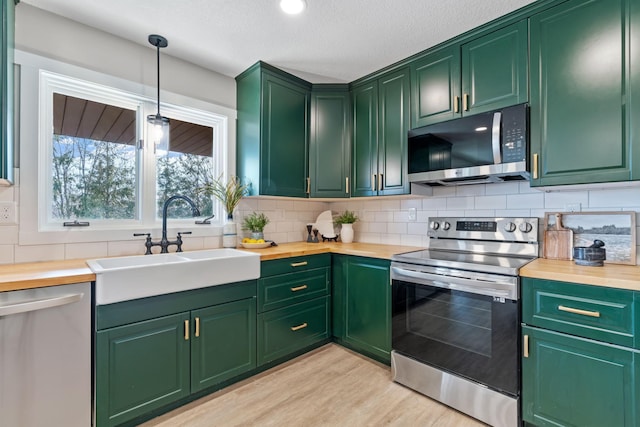 kitchen featuring a sink, wood counters, backsplash, and appliances with stainless steel finishes