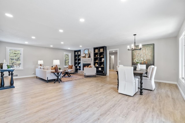 dining area featuring light wood-style flooring, recessed lighting, a fireplace, and baseboards