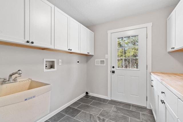 clothes washing area featuring visible vents, cabinet space, electric dryer hookup, washer hookup, and a sink