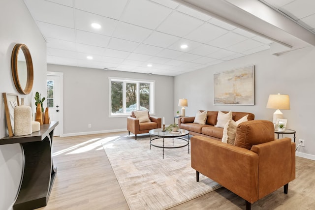 living area with light wood-style flooring, recessed lighting, a paneled ceiling, and baseboards