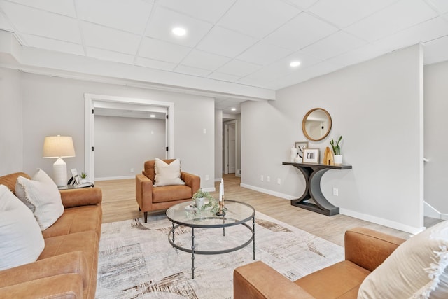 living area featuring recessed lighting, wood finished floors, baseboards, and a paneled ceiling