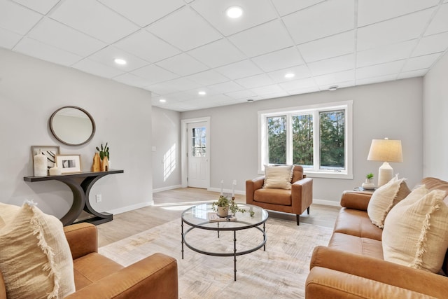 living room featuring recessed lighting, a drop ceiling, baseboards, and light wood-style floors