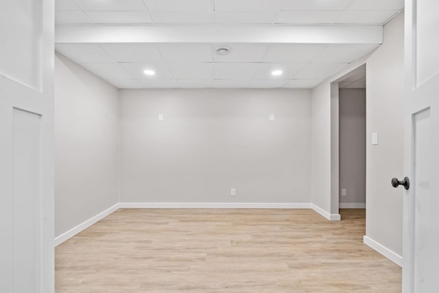 basement with a paneled ceiling, light wood-type flooring, baseboards, and recessed lighting