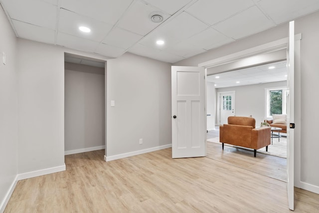 basement with recessed lighting, a drop ceiling, light wood-style flooring, and baseboards