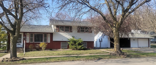 split level home featuring a detached garage and a front yard