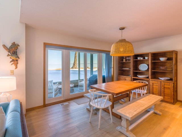 dining room with visible vents, light wood-style flooring, and baseboards