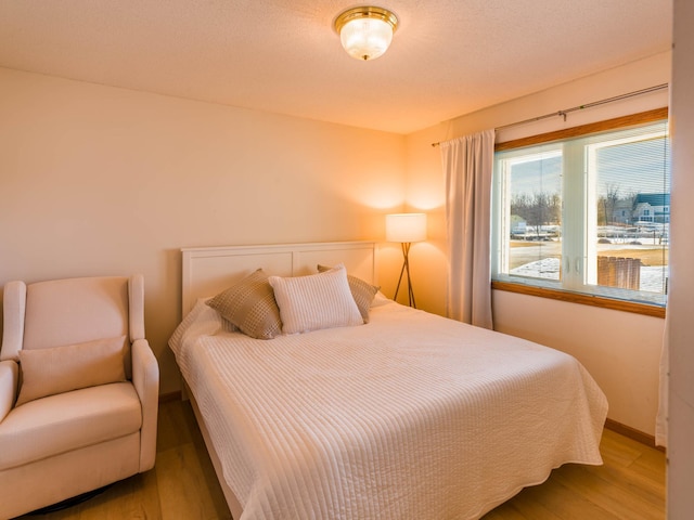 bedroom with baseboards and wood finished floors