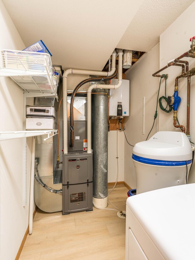 utilities featuring tankless water heater and washer / clothes dryer