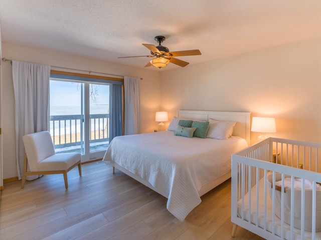 bedroom featuring a textured ceiling, light wood-style floors, a ceiling fan, and access to outside